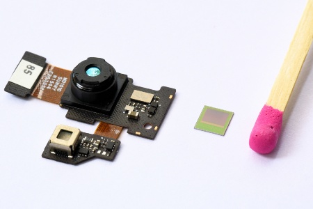 Das 3D-Kameramodul des neuen PHAB2 Pro von Lenovo (links) mit dem enthaltenen REAL3™ Bildsensorchip von Infineon im Größenvergleich